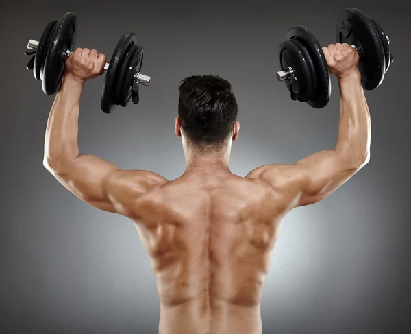 Bodybuilder back with dumbbells — Stock Photo, Image