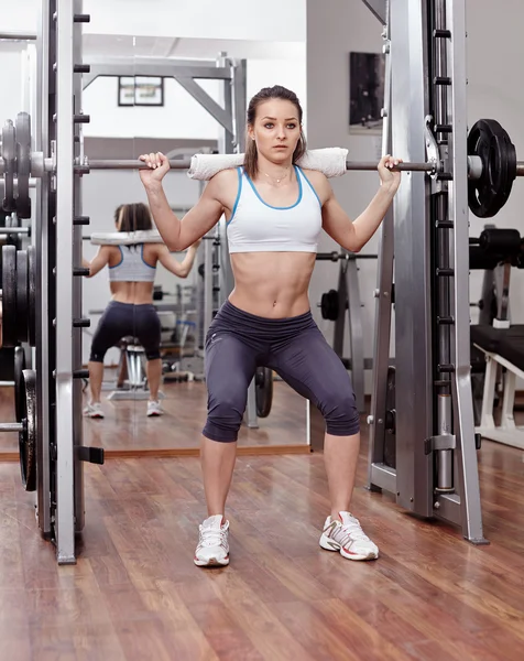 Atletische vrouw doen squats op de sportschool — Stockfoto