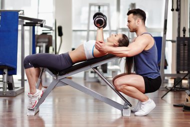 Personal trainer helping woman at gym
