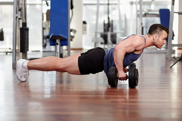 Hombre haciendo flexiones en pesas — Foto de Stock