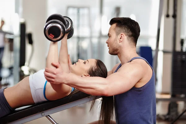 Personal Trainer hilft Frau im Fitnessstudio — Stockfoto