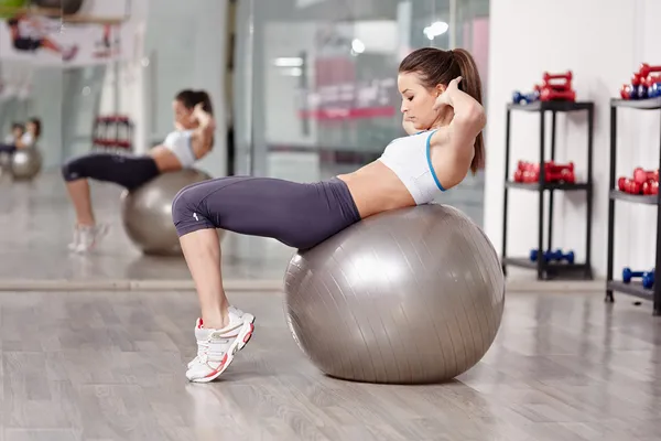 Mujer haciendo abdominales crujidos — Foto de Stock