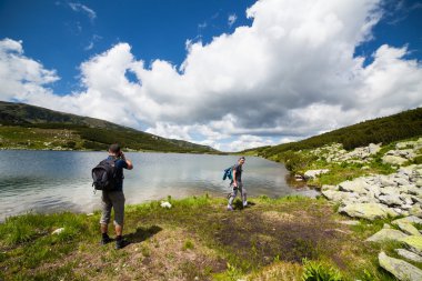 yürüyüşçüler dağlar göle yakın