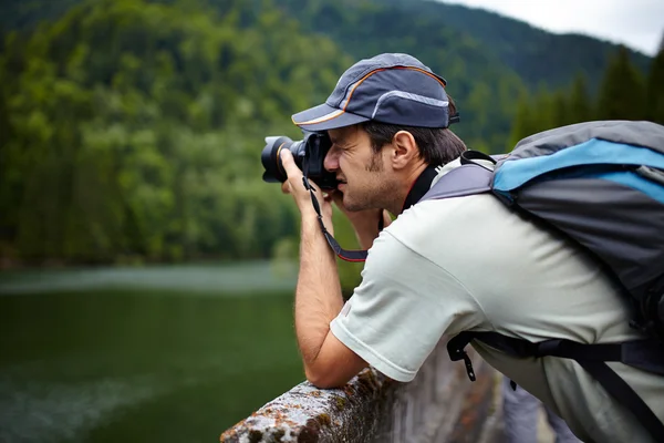 Tourist taking photos of a lake Stock Image