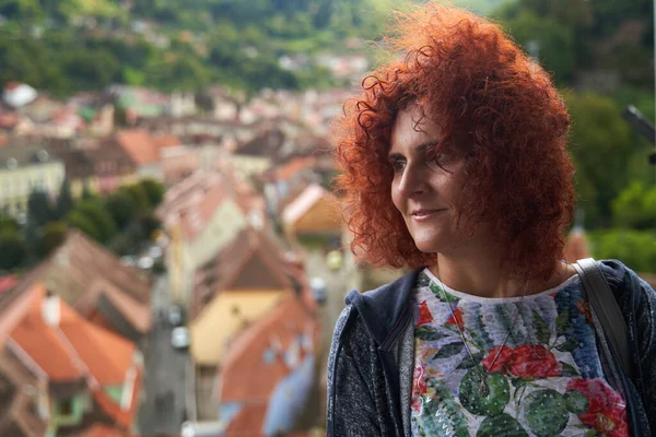 背景に古い町と現在赤頭の女性の肖像画 選択的な焦点 — ストック写真