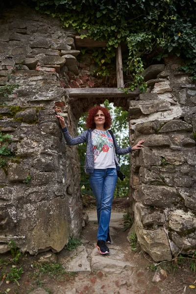 在一个有巨大石墙的历史遗迹附近 一位带着相机的女游客 — 图库照片