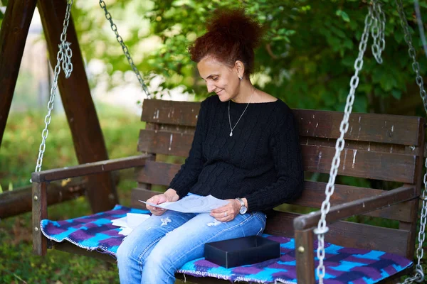 Woman Reading Amusing Letter While Sitting Swing — Stock Photo, Image