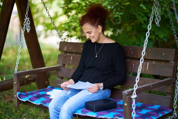 Frau Liest Lustigen Brief Während Sie Schaukel Sitzt — Stockfoto