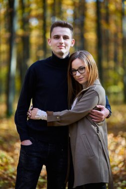 Sonbaharın ortasında meşe ormanında genç bir çift.