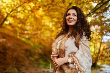 Güz ortasında nehrin kenarında güzel bir genç kadının portresi.