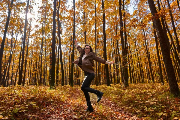 年轻女子在森林里高高地跳着 — 图库照片