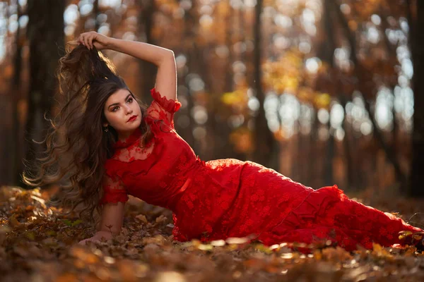 橡木林中一位身穿红衣的年轻漂亮女子的全长迷人画像 — 图库照片