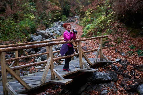 Nehrin Üzerindeki Köprüde Kameralı Bir Kadın Seyahat Fotoğrafçısı Dağlarda Canlı — Stok fotoğraf