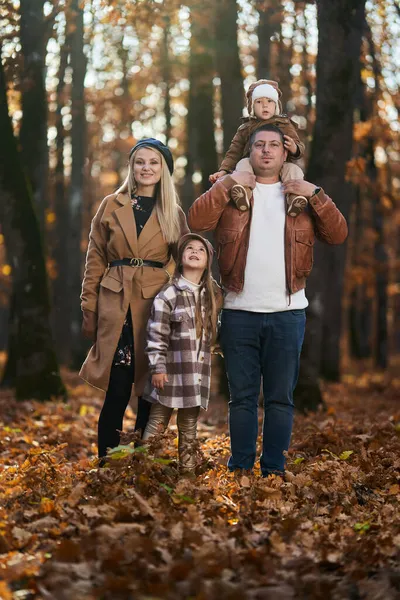 秋天五彩缤纷的橡木森林里有男孩和女孩的年轻家庭 — 图库照片