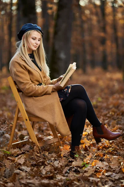 Młoda Kobieta Siedząca Krześle Czytająca Książkę Lesie Czas Jesienny — Zdjęcie stockowe