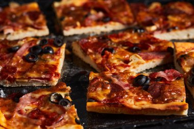 Tahtadaki tepside ev yapımı pepperoni pizza.