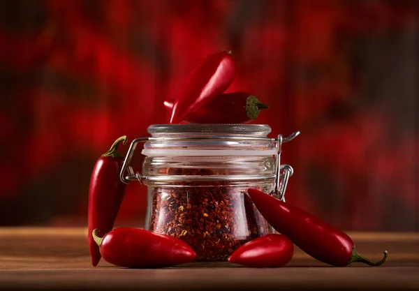 Hot Chili Rauwe Peper Vlokken Een Pot Een Houten Plank — Stockfoto