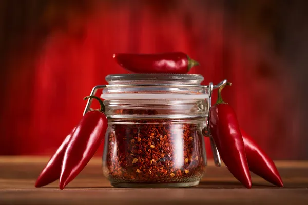 Chili Roh Und Paprika Flocken Einem Glas Auf Einem Holzbrett — Stockfoto