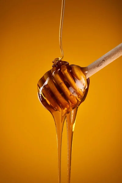 Closeup Honey Dripping Wooden Dipper Isolated Yellow Background — Stock Photo, Image
