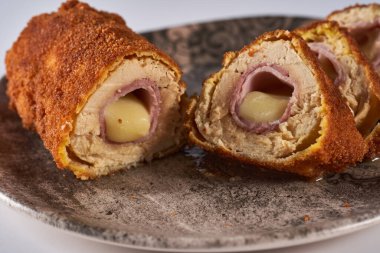 Cordon bleu - tavuk göğsü, jambon ve çedar peynirli dürüm, yakın plan.