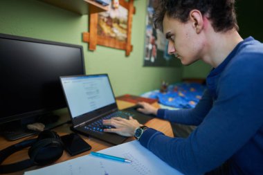 Bilgisayarı, bilgisayarı, cep telefonu ve bilgisayarı ile evde çalışan bir yazılım geliştiricisi.