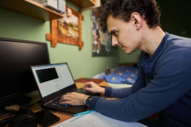 Bilgisayarı, bilgisayarı, cep telefonu ve bilgisayarı ile evde çalışan bir yazılım geliştiricisi.