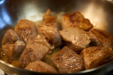 Pork chops, sirloin, searing in a stainless steel pan on the stove