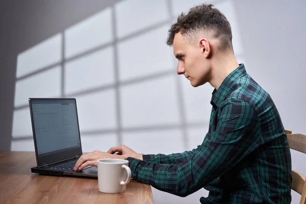 Joven Hombre Negocios Tomando Café Mientras Trabaja Computadora Portátil — Foto de Stock