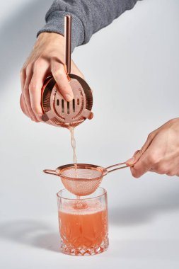 İsimsiz barmen elleri kokteyl hazırlıyor.