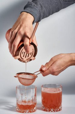 İsimsiz barmen elleri kokteyl hazırlıyor.