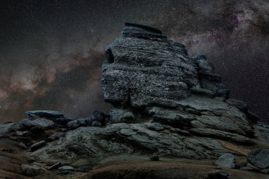 Geceleri Romanya Sfenksi, arka planda Samanyolu ile erozyon sonucu oluşan jeolojik fenomen
