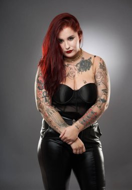 Cazibe artı beden modeli iç çamaşırlı dövmeler ve gri arka planda deri.