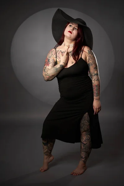 サイズプラス美しい女性でタトゥー 黒のドレスと帽子 魅力的なショット — ストック写真
