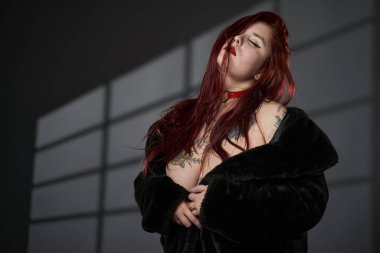 Redhead plus size woman with tattoos in lingerie, studio shot clipart