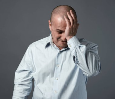 Mutsuz bir iş adamı. Başarısızlık ifadesi var. Gri arka planda.