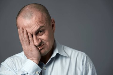 Mutsuz bir iş adamı. Başarısızlık ifadesi var. Gri arka planda.