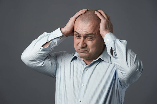 Зрелый бизнесмен с сильной мигренью из-за стресса на работе
