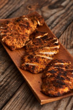 Tahtada otlarla dilimlenmiş tavuk göğsü.