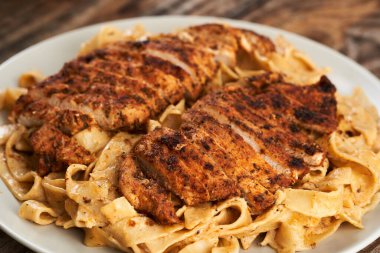 Alfredo soslu fettuccine ile karartılmış tavuk göğsü.