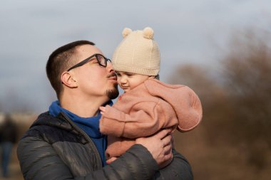 Genç baba ve küçük kızı parkın dışında harika vakit geçiriyorlar.