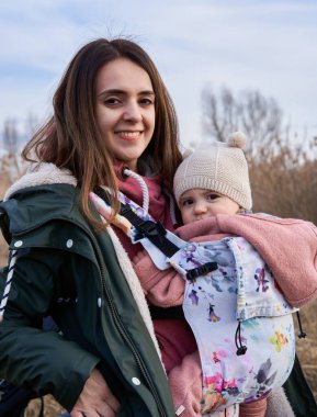 Genç bir anne gün batımında kızını parkın dışında bir yerleşim bölgesinde tutuyor.