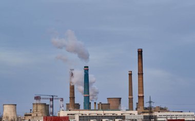 Atmosferde yükselen bacalar ve kalın beyaz dumanlı sanayi kirliliği kavramı