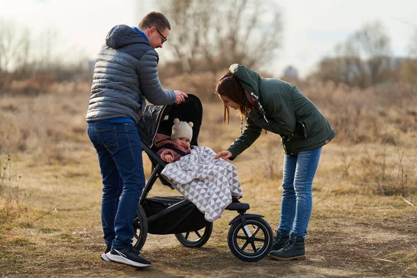 Familia Joven Con Pequeña Niña Caminando Por Parque Con Carruaje —  Fotos de Stock