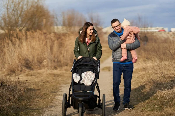 Junge Familie Mit Kleinem Mädchen Läuft Mit Kinderwagen Durch Park — Stockfoto