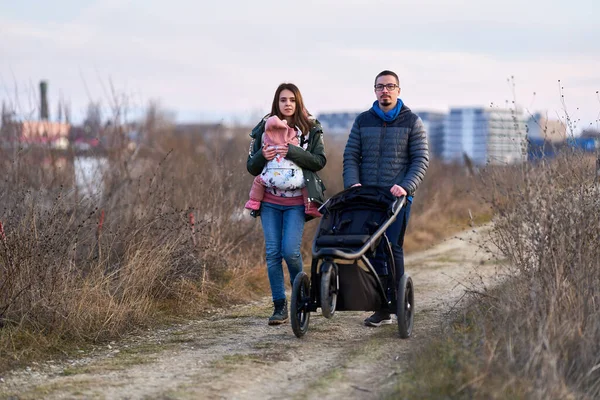 Família Jovem Com Sua Filhinha Andando Pelo Parque Com Carruagem — Fotografia de Stock