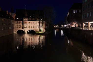 Geceleri nehir kıyısındaki eski binalar.