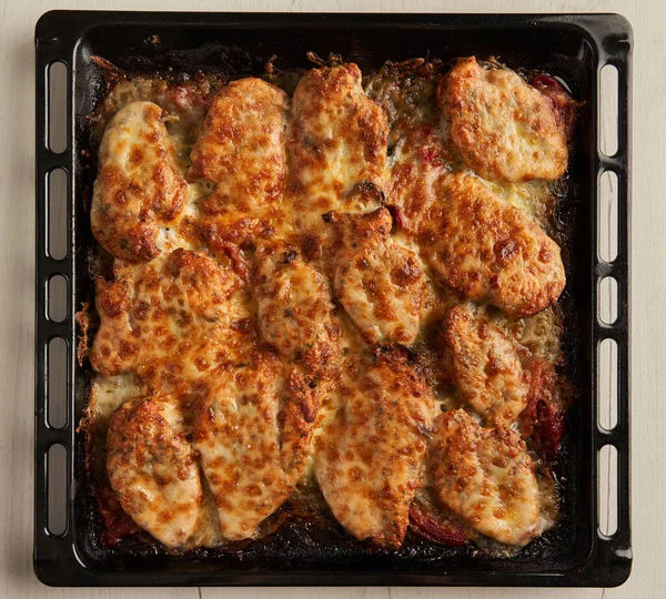 用融化的意大利面和切达放在盘子里烘烤的烤鸡胸炉 — 图库照片