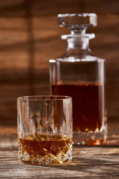 波旁威士忌或苏格兰威士忌配上精致的酒瓶和木制木板上漂亮的杯子 — 图库照片