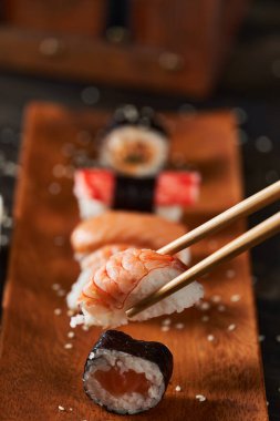 Kırsal ahşap tabakta servis edilen taze suşi çeşitleri.