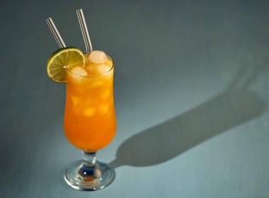 Buzlu turuncu alkolsüz kokteyl, mavi üzerine ferahlatıcı bir yaz içeceği.